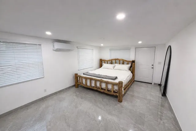 a spacious bedroom with a bed and a window