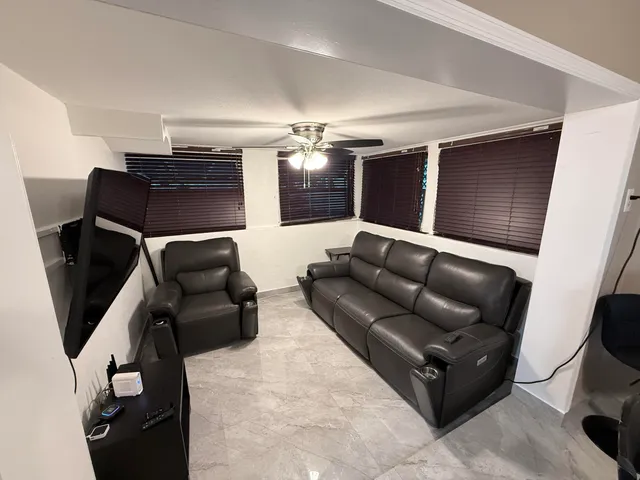 a living room with furniture and a ceiling fan