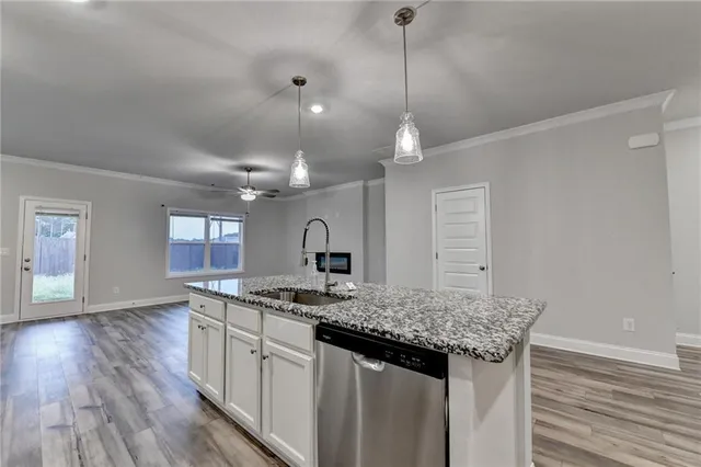an empty room with wooden floor chandelier and windows