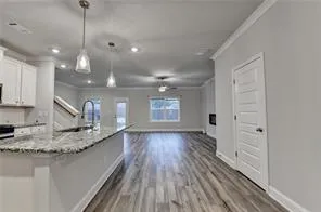 a large kitchen with stainless steel appliances kitchen island granite countertop a large counter top a sink and a chandelier