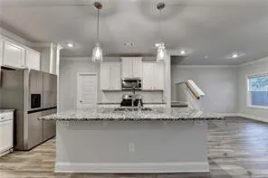 a kitchen with stainless steel appliances granite countertop a sink refrigerator and cabinets