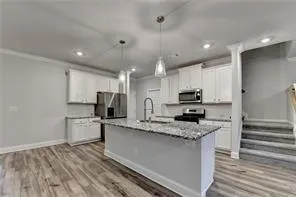 a kitchen with stainless steel appliances granite countertop a stove a sink and a microwave