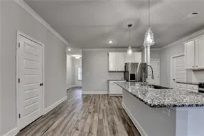 a kitchen with stainless steel appliances kitchen island granite countertop a stove sink and cabinets
