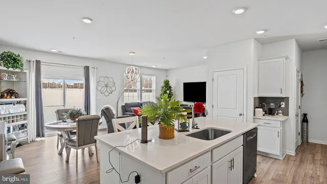 a kitchen with white cabinets and sink