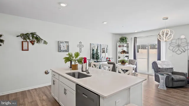 a kitchen with a sink dishwasher and a stove with wooden floor