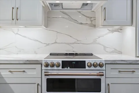 a stove top oven sitting inside of a kitchen