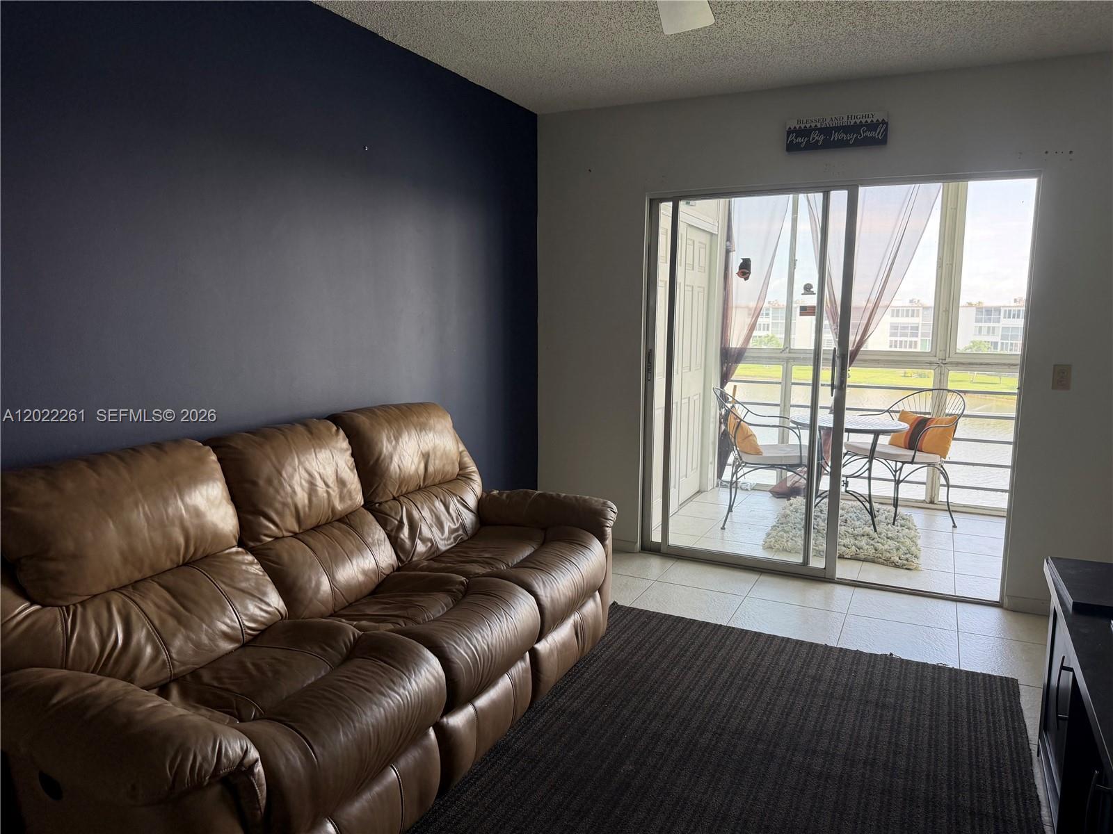 4043 Cornwall C, Unit 4043 Boca Raton, FL 33434 - Photo 4 of 16 a living room with furniture and a floor to ceiling window