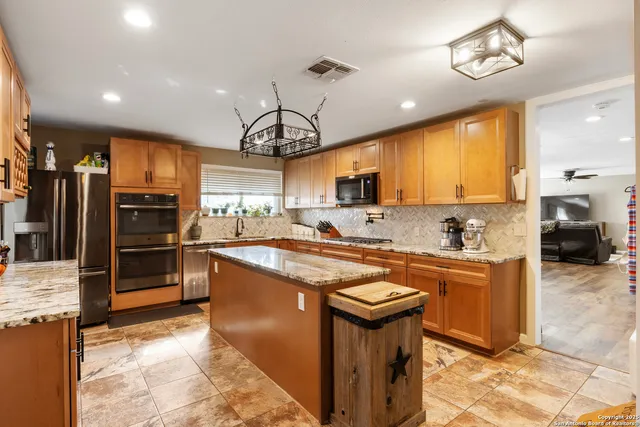 a kitchen with stainless steel appliances granite countertop a sink stove and refrigerator