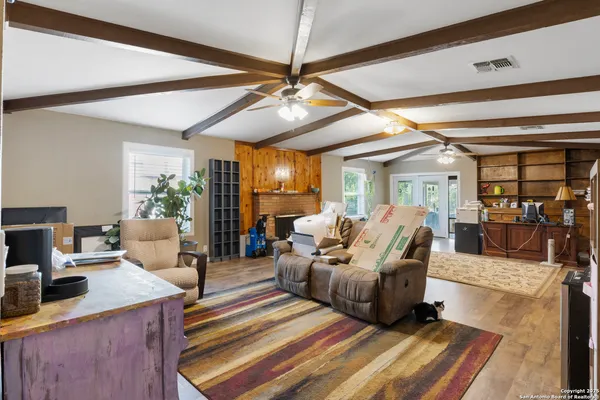 a living room with furniture a dining table and chairs with wooden floor