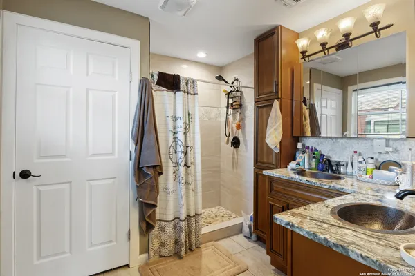 a bathroom with a granite countertop sink a toilet and a shower