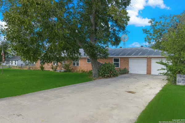 a front view of a house with a garden and trees