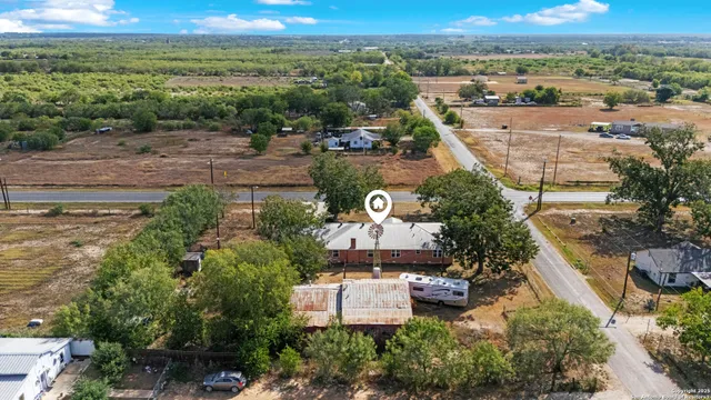 aerial view of a house with a yard and large trees