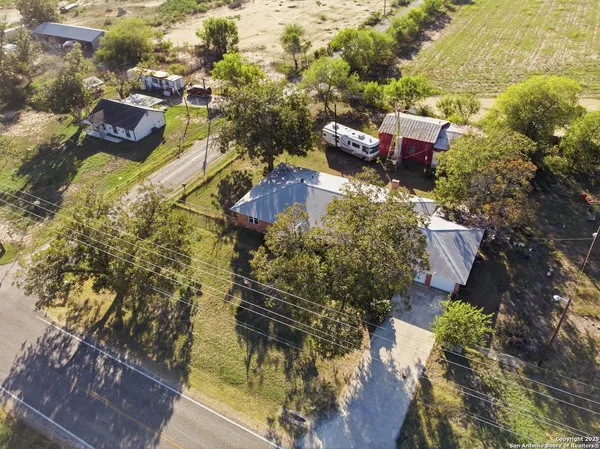 an aerial view of ocean and residential houses with outdoor space