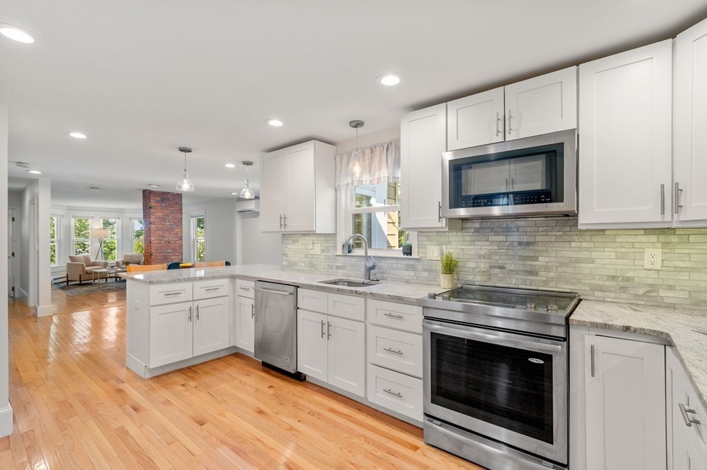 91 Fayette Street, Unit 91 Watertown, MA 02472 - Photo 8 of 21 a kitchen with stainless steel appliances granite countertop wooden cabinets granite counter tops a stove a sink and a microwave