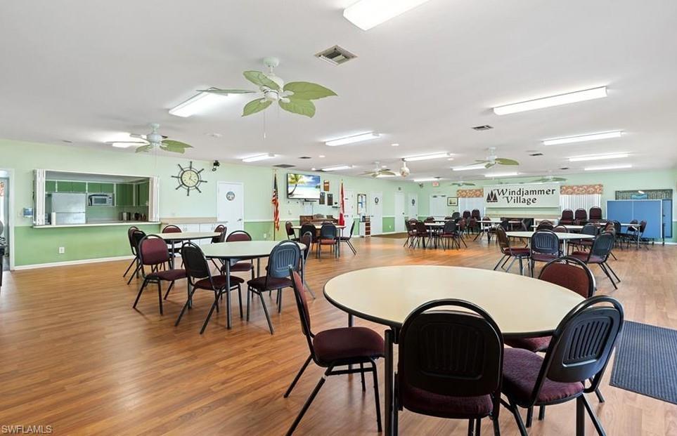 76 Atlantic Way, Unit 76 Naples, FL 34104 - Photo 6 of 18 a dining room with wooden floor a chandelier a wooden table and chairs