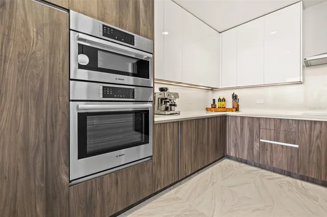 a kitchen with stainless steel appliances granite countertop a sink a stove a refrigerator with wooden floor and cabinets