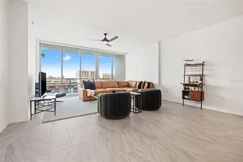 a living room with furniture a ceiling fan and a flat screen tv