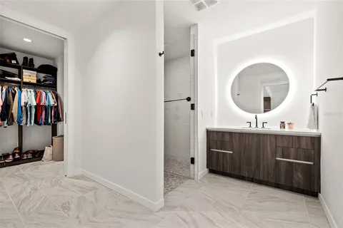 a view of walk in closet with clothes and shoes