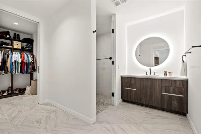 a view of walk in closet with clothes and shoes