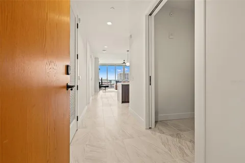 a kitchen with stainless steel appliances a dining table chairs refrigerator and microwave