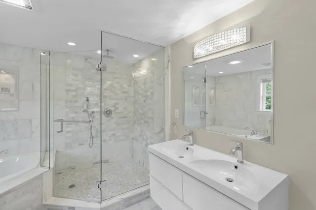 a bathroom with a shower a sink and mirror