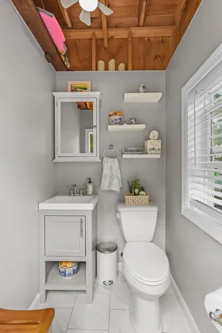 a white toilet sitting next to a bathroom sink and vanity