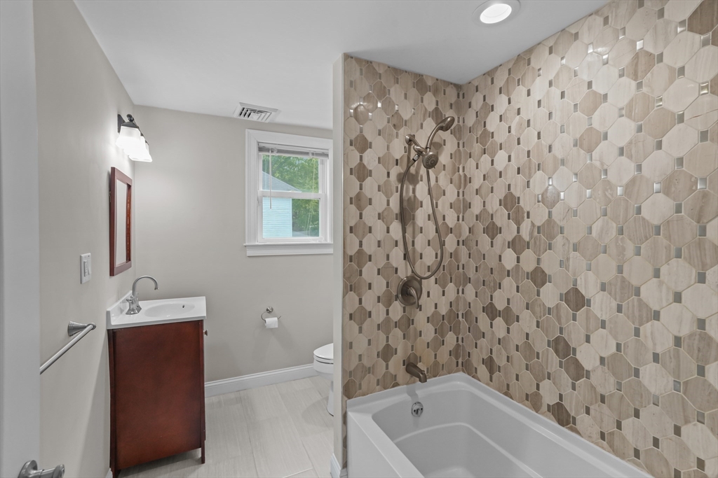 51 Faxon Street Braintree, MA 02184 - Photo 8 of 31 a bathroom with a bathtub sink vanity and toilet