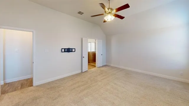an empty room with closet and a ceiling fan