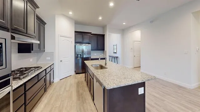 a kitchen with stainless steel appliances granite countertop a sink stove and refrigerator