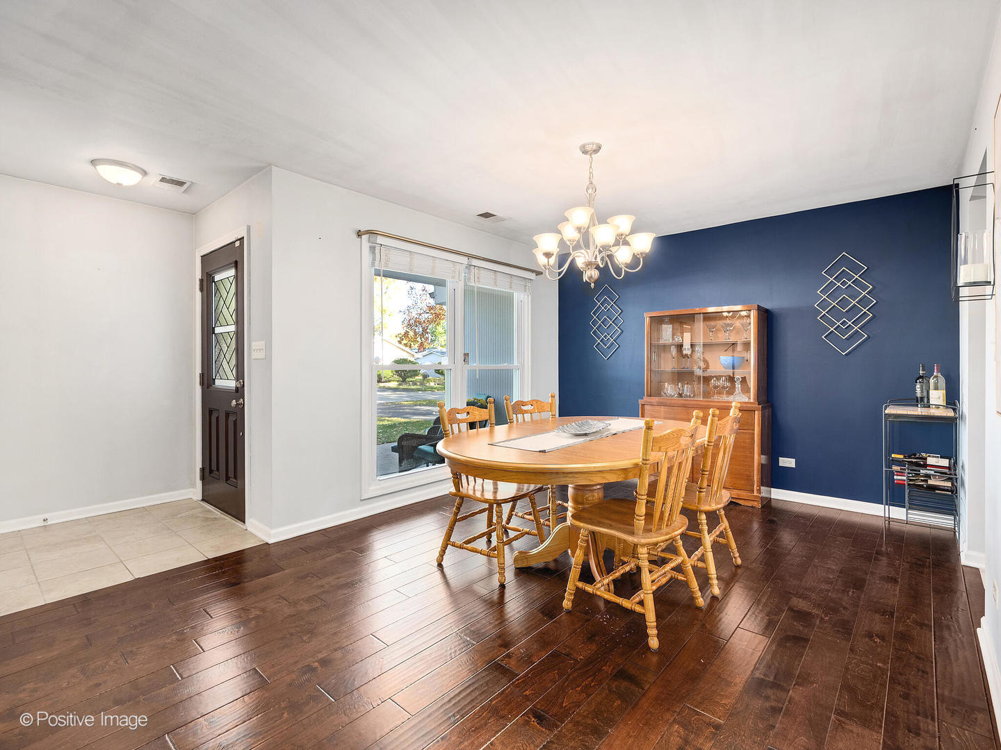 1517 Sequoia Lane Darien, IL 60561 - Photo 5 of 27 a dining room with wooden floor a chandelier a wooden table and chairs