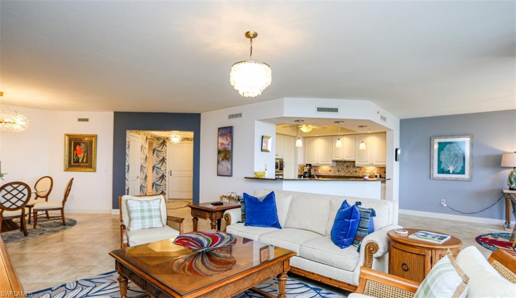 1060 Borghese Lane, Unit 603 Naples, FL 34114 - Photo 34 of 50 Living room with baseboards, a notable chandelier, visible vents, and light tile patterned floors