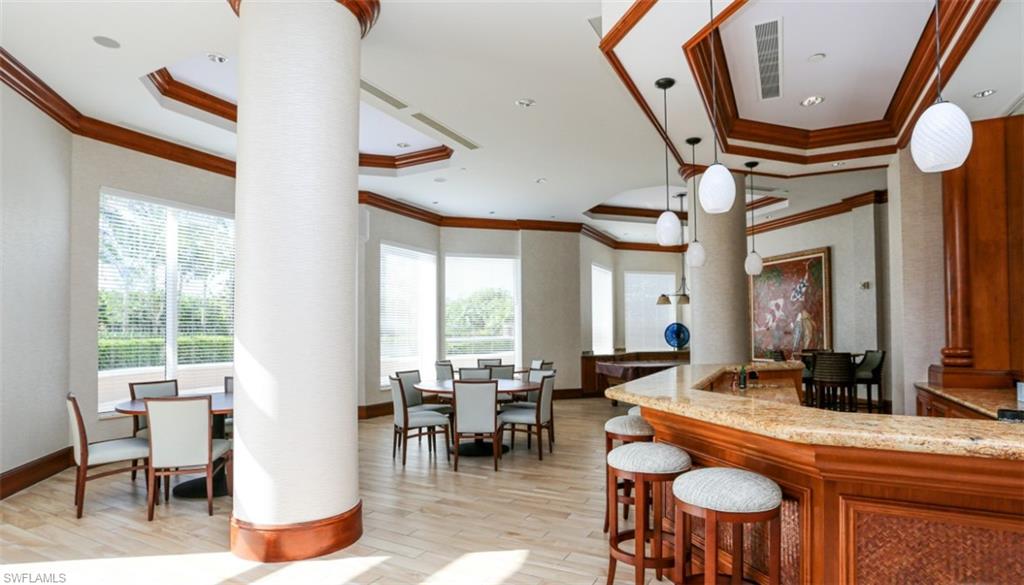 1060 Borghese Lane, Unit 603 Naples, FL 34114 - Photo 4 of 50 Kitchen with decorative columns, a raised ceiling, ornamental molding, and light wood-style floors