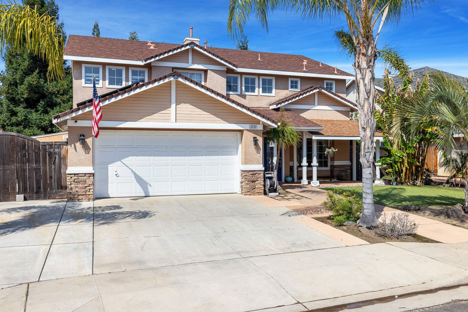 3232 Greenfield Avenue Clovis, CA 93611 - Photo 2 of 38 a front view of a house with a yard and garage
