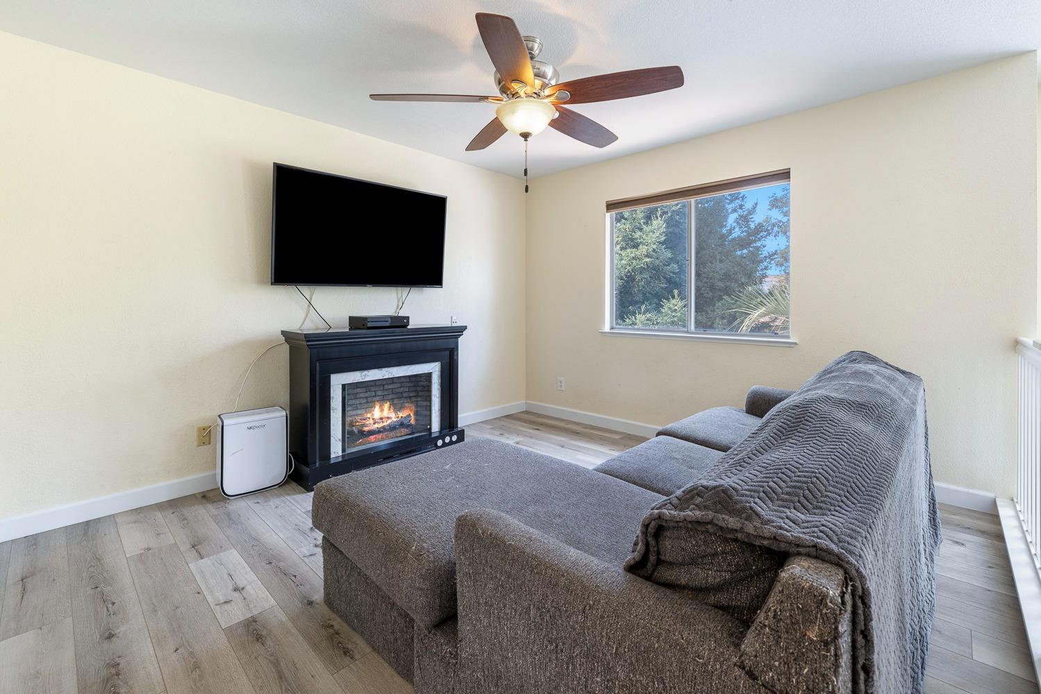 3232 Greenfield Avenue Clovis, CA 93611 - Photo 27 of 38 a living room with furniture and a flat screen tv