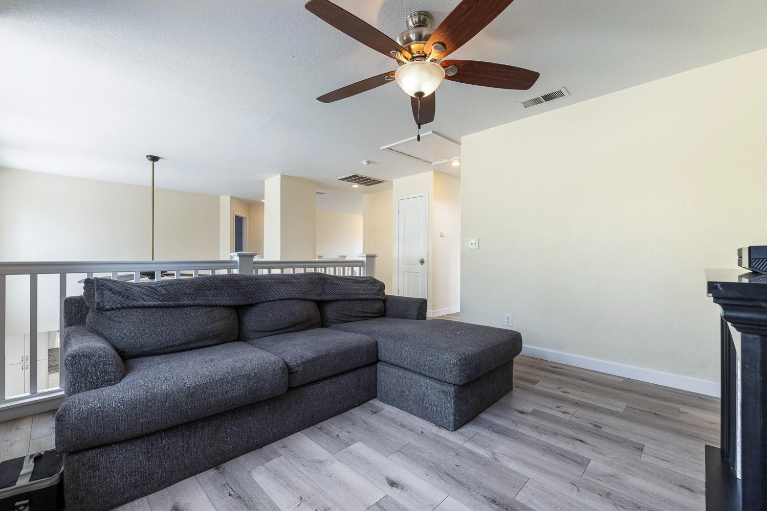 3232 Greenfield Avenue Clovis, CA 93611 - Photo 29 of 38 a living room with furniture and a wooden floor