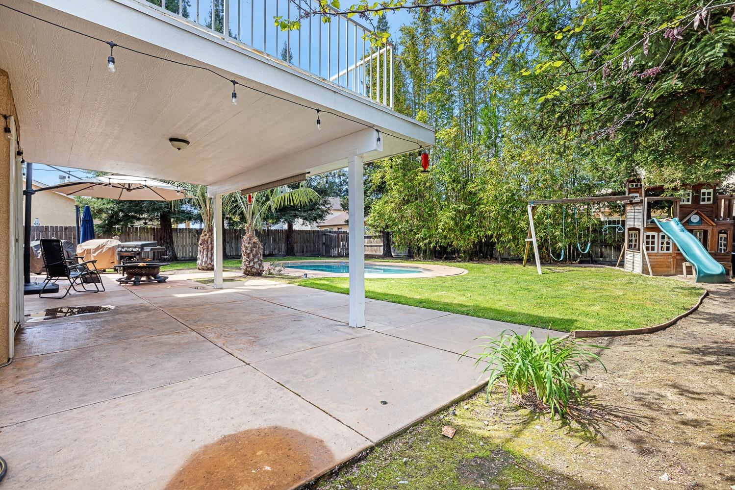 3232 Greenfield Avenue Clovis, CA 93611 - Photo 33 of 38 a view of a patio with a table and chairs under an umbrella