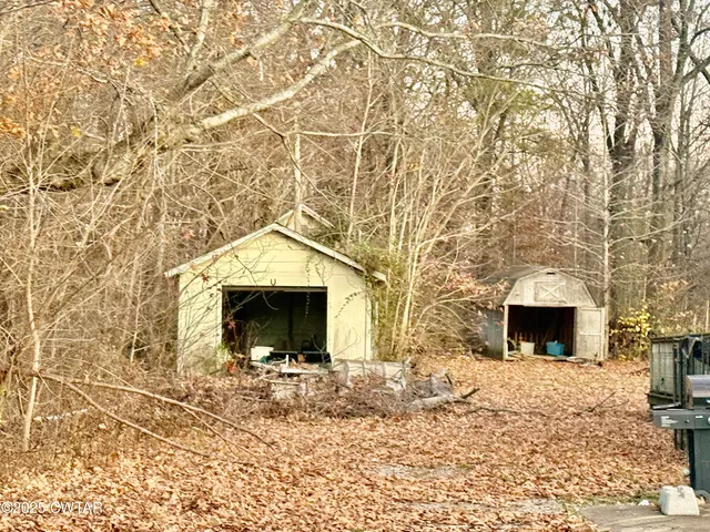 a view of empty room with a fireplace and wooden floor