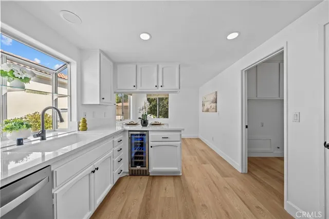 a kitchen with stainless steel appliances white cabinets and wooden floors