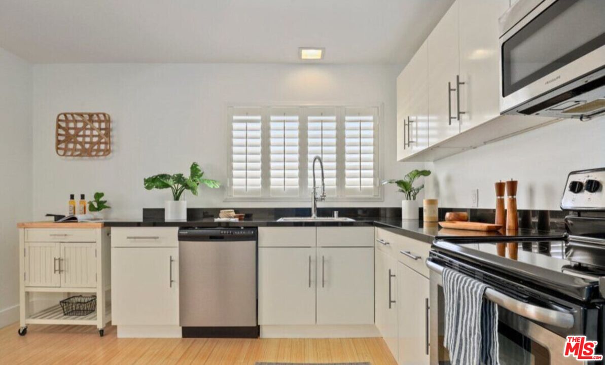 6624 South Springpark Avenue, Unit 5A Los Angeles, CA 90056 - Photo 11 of 23 a kitchen with stainless steel appliances granite countertop a sink a stove a chimney a refrigerator and cabinets