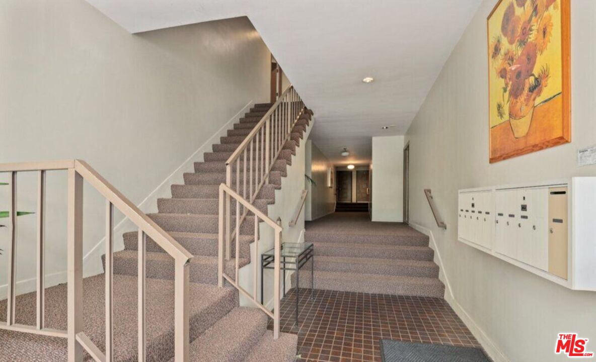 6624 South Springpark Avenue, Unit 5A Los Angeles, CA 90056 - Photo 21 of 23 a view of staircase with lots of frames on wall and a black gate