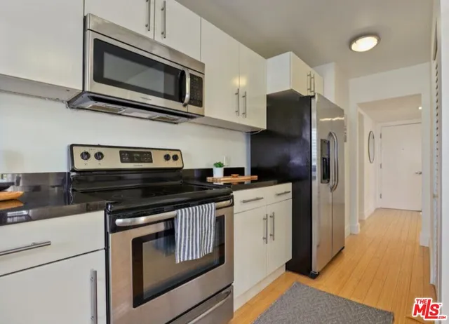 a kitchen with stainless steel appliances granite countertop a stove microwave and refrigerator