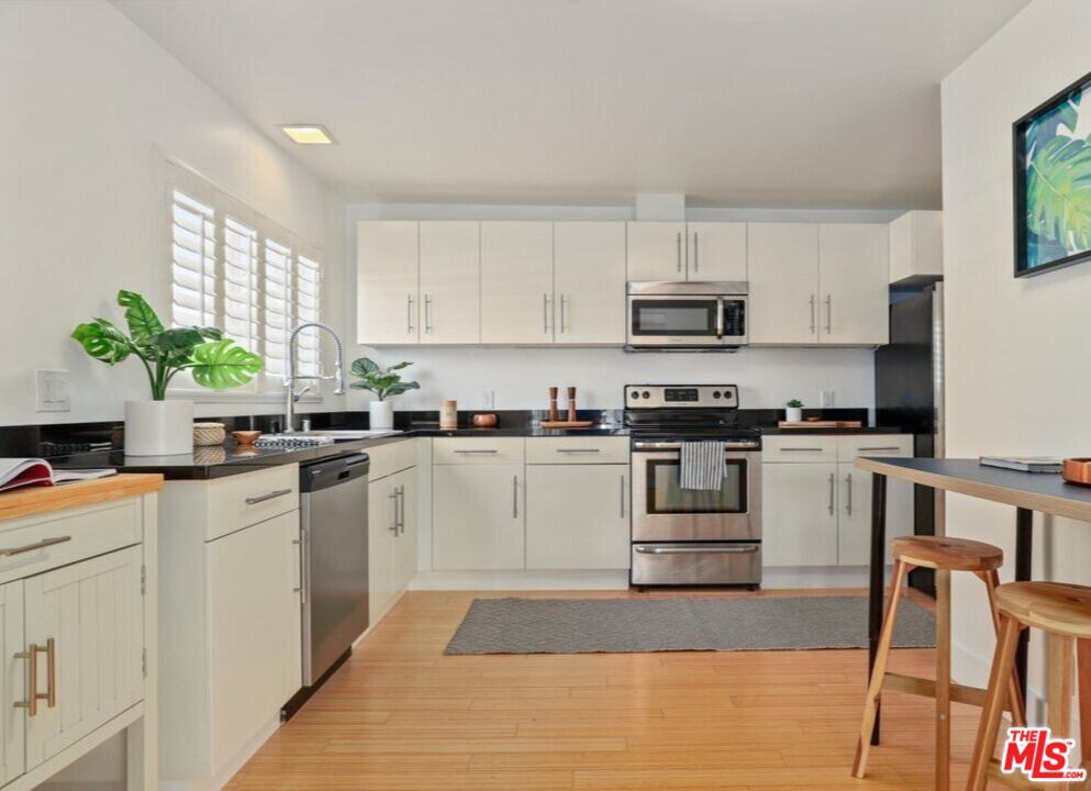 6624 South Springpark Avenue, Unit 5A Los Angeles, CA 90056 - Photo 10 of 23 a kitchen with granite countertop white cabinets and white appliances