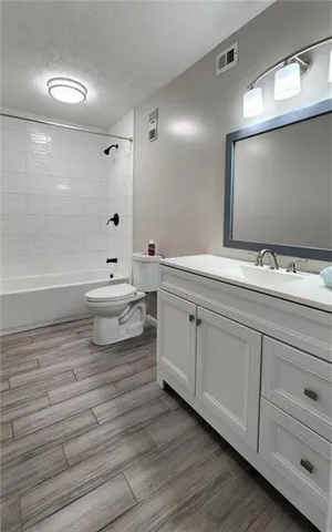 a bathroom with a double vanity sink mirror and toilet