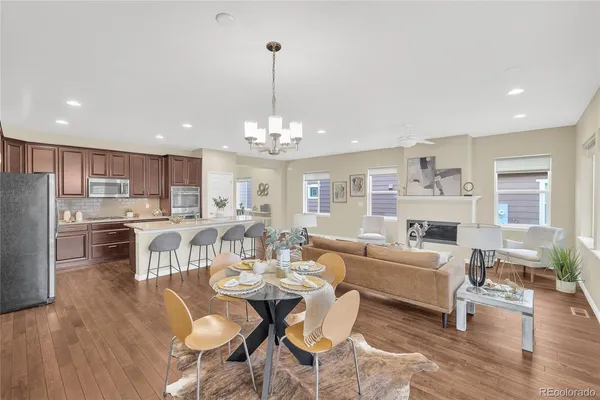 a view of a dining room with furniture a kitchen and chandelier