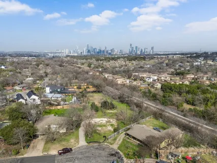 an aerial view of residential houses with outdoor space and trees