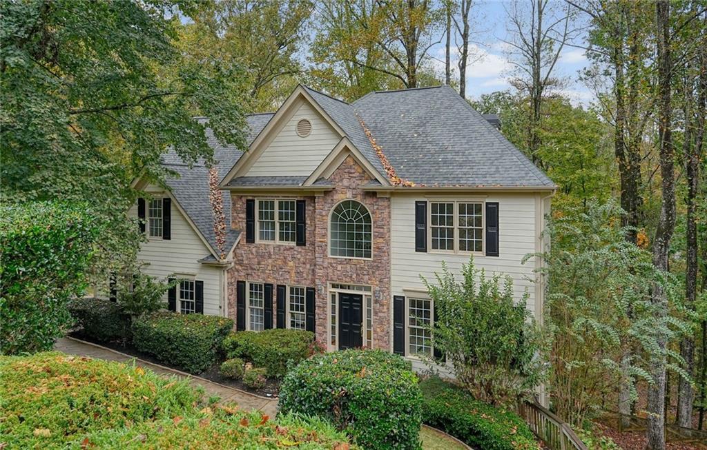 a house view with a garden and large trees