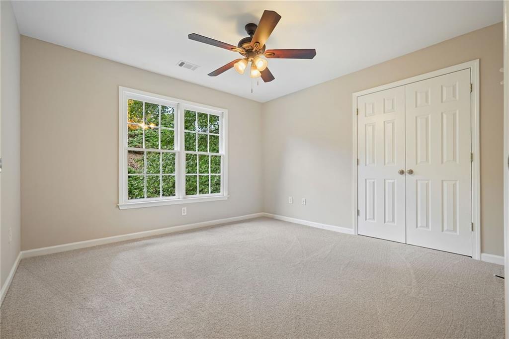 4555 Dennington Trace Cumming, GA 30028 - Photo 39 of 64 an empty room with window and a ceiling fan