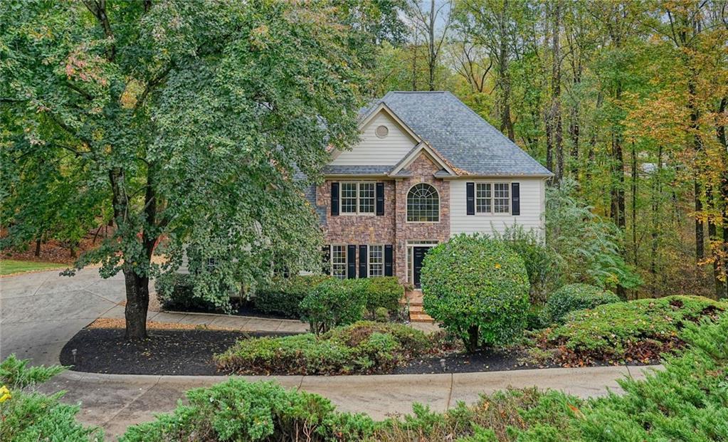 4555 Dennington Trace Cumming, GA 30028 - Photo 64 of 64 a front view of a house with a yard and trees