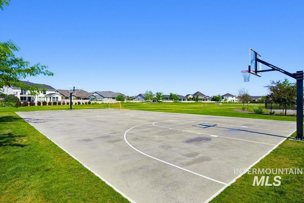 5897 West Riva Capri Street Meridian, ID 83646 - Photo 45 of 50 Recreational basketball court with painted lines and two hoops, surrounded by expansive green lawn