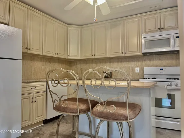 a view of a kitchen with stainless steel appliances granite countertop a stove a refrigerator and cabinets